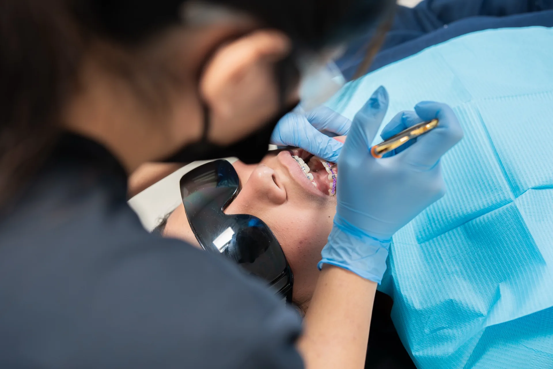 Smiling Oasis Dental patient with colorful braces