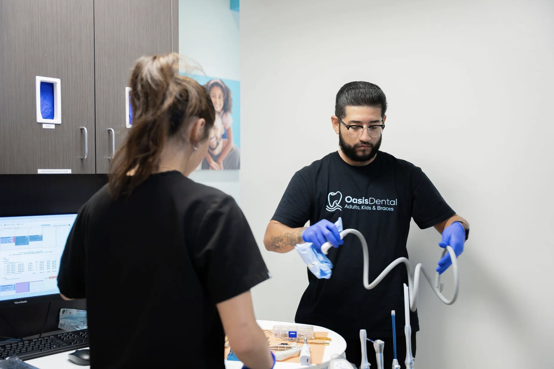 Oasis Dental team members preparing dental equipment in a treatment room