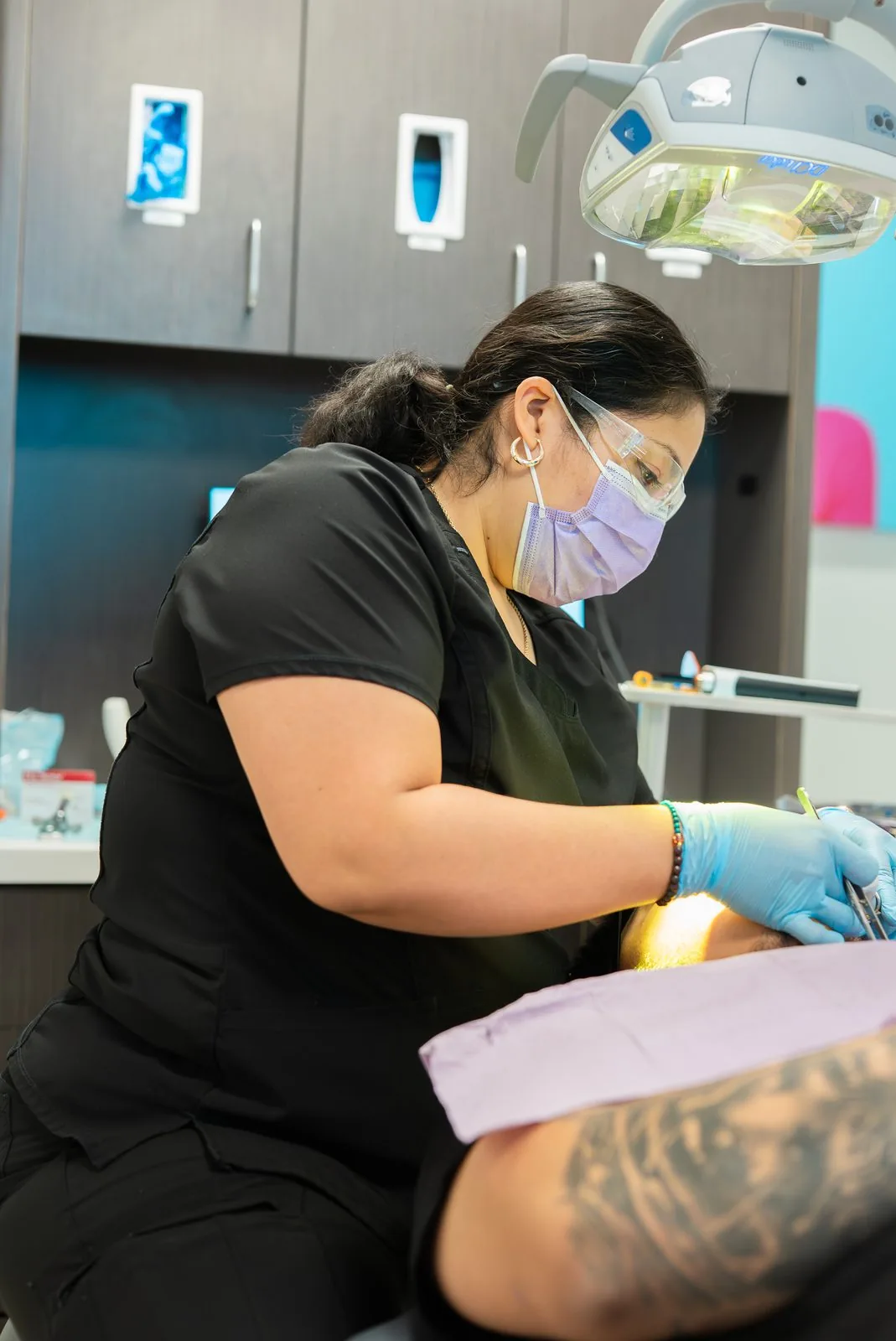 A dental assistant providing treatment to a patient at Oasis Dental