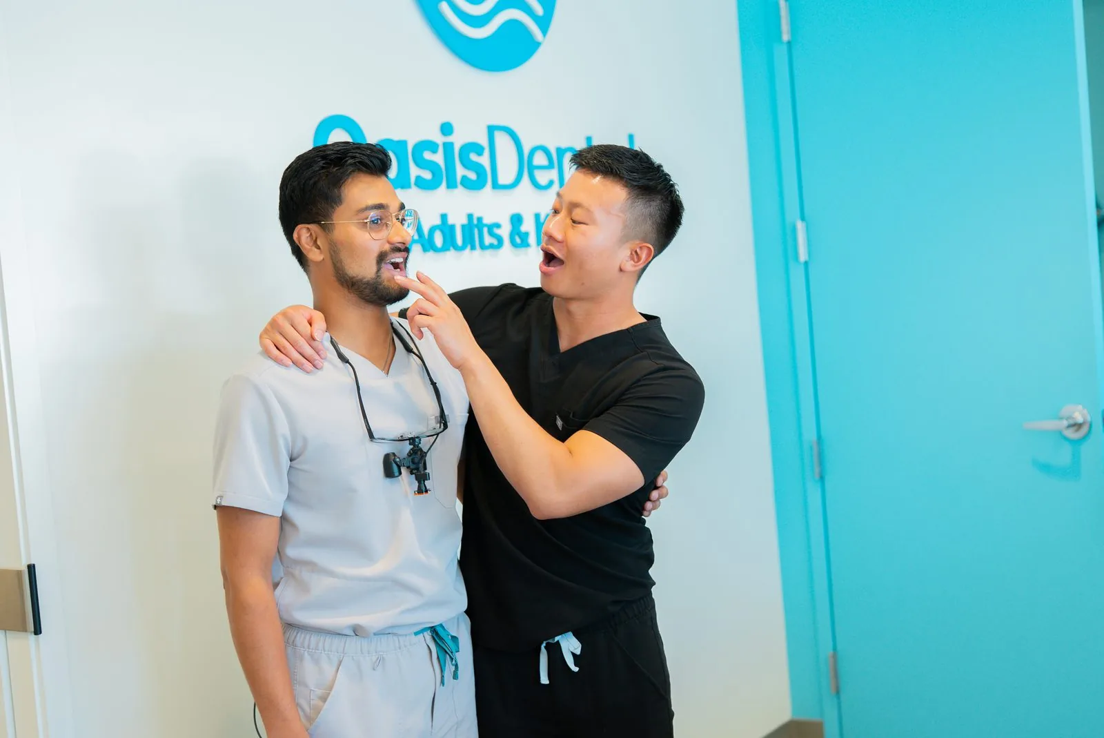Dr. Dinesh and Dr. Ryan laughing together in the Aurora office lobby