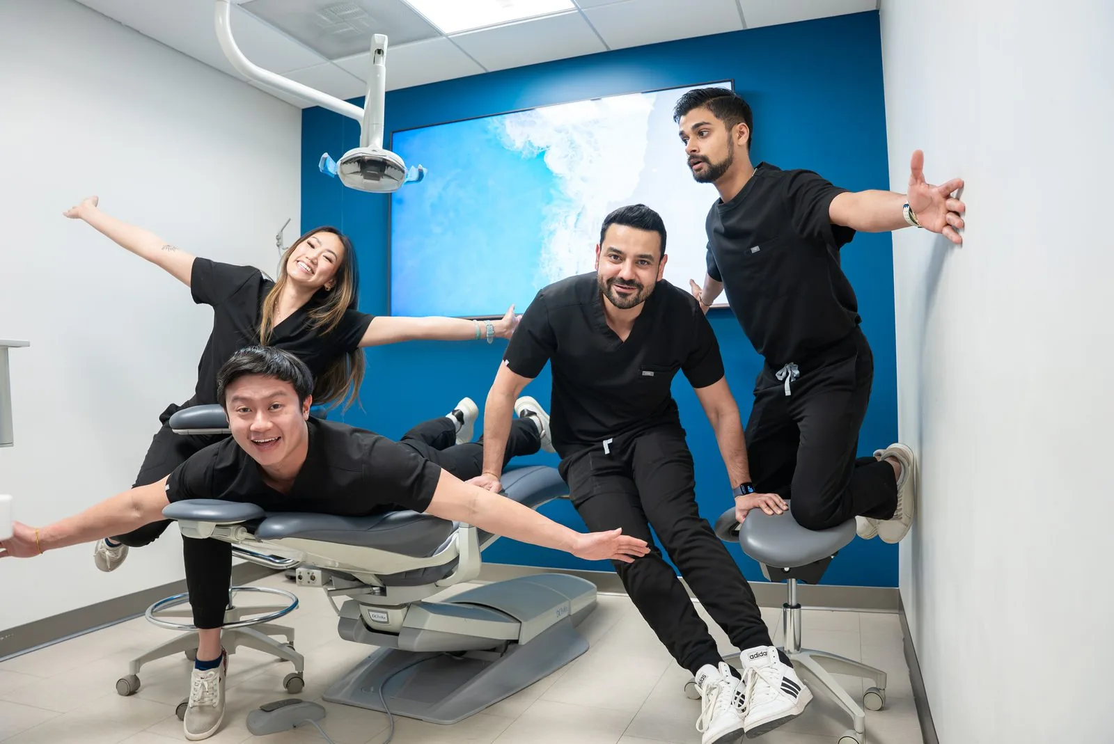 Four Oasis Dental doctors posing playfully in a treatment room