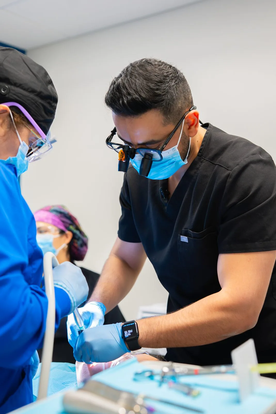 Dentist and dental assistant working together chairside on a patient at Oasis Dental